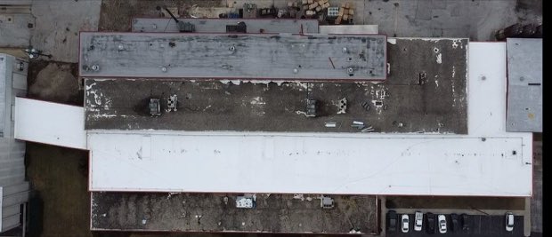 Aged low-slope roof showing surface deterioration across the field.