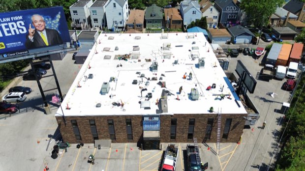 Urban commercial roof from above, mechanical equipment distributed across the field.