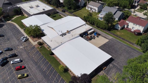 Suburban low-rise property with metal and low-slope roof sections.