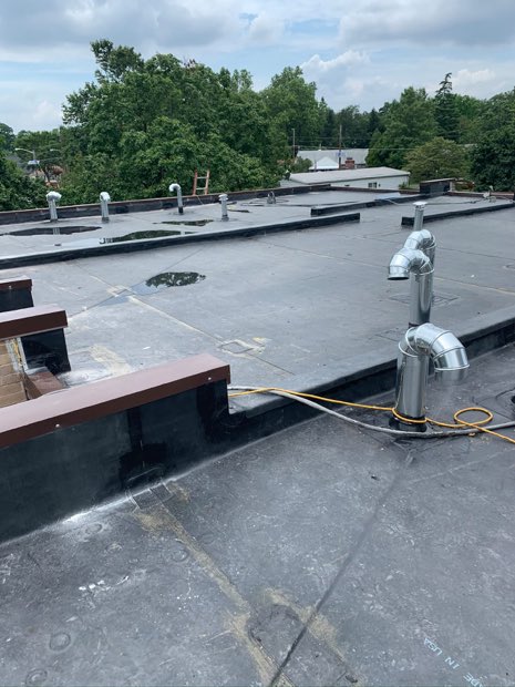 Vent stack and flashing detail on a completed modified bitumen roof.