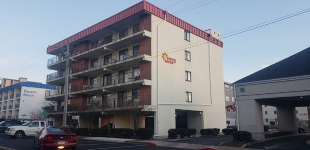Mid-rise residential building elevation before roof work begins.