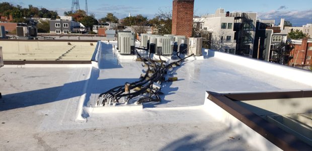 Urban rooftop between masonry buildings, water tower on the skyline.