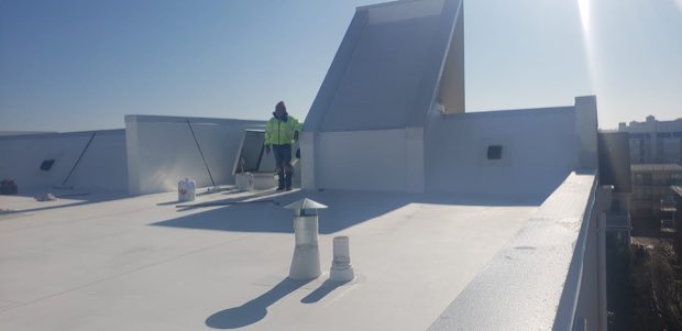 Crew member crossing a completed reflective roof.