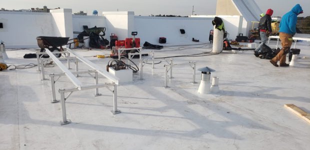 Crew and equipment staged across a roof during production.
