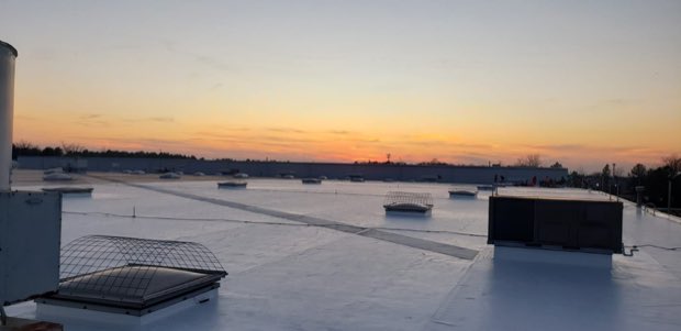 Sunset over a completed low-slope roof.