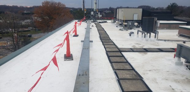 Drainage channel and perimeter markers on a white roof.