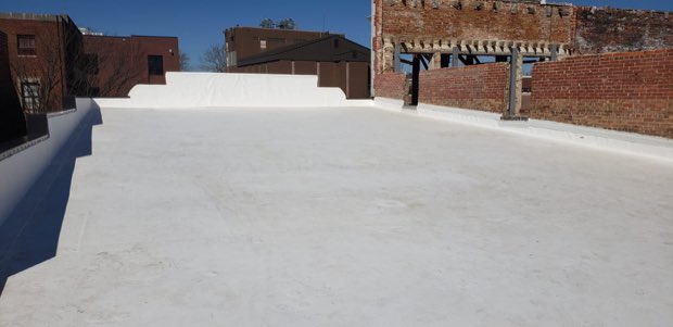 Completed white roof against a brick elevation.