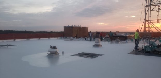 Early-morning membrane installation, crew working the field.