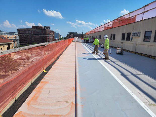 Crew installing membrane behind perimeter netting.