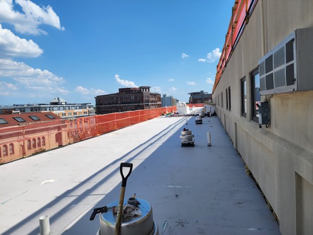 Roof looking down an urban block, membrane run in progress.