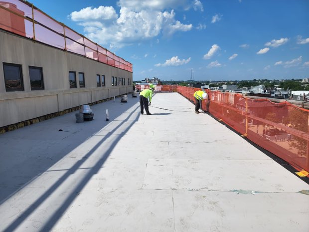 Crew on an open roof under clear sky.