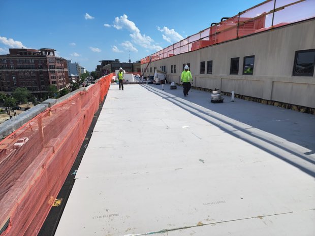 Long membrane run with crew working the far end.