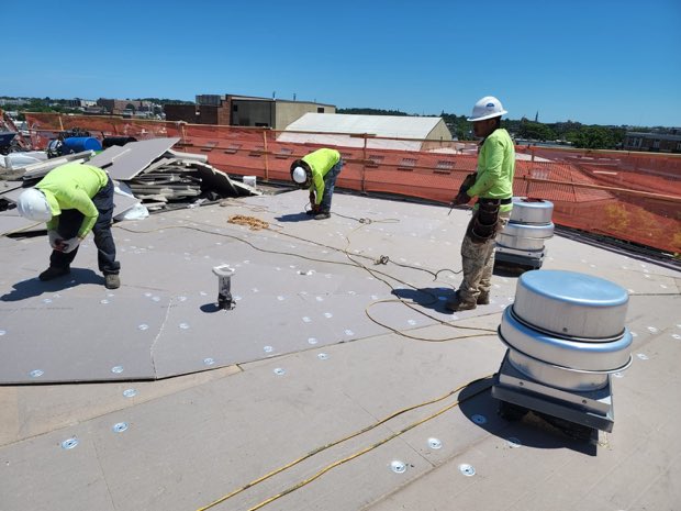 Tear-off in progress — old material being cleared from the deck.