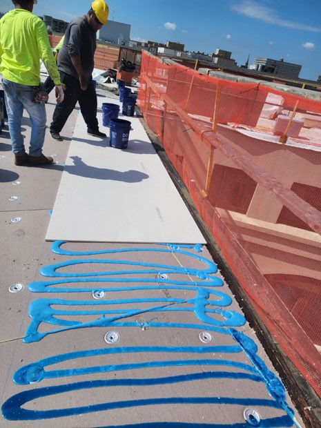 Insulation board set in adhesive across the deck.