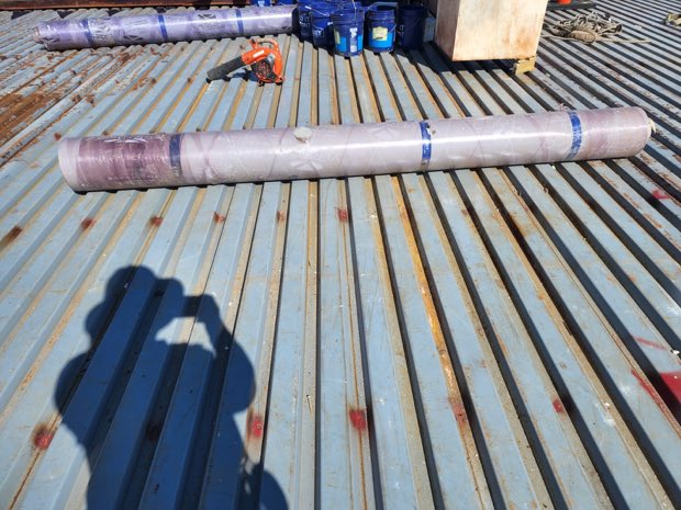 Rolled membrane staged on a metal deck.