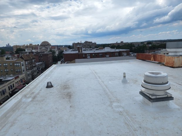Completed roof with a landmark dome in the distance.