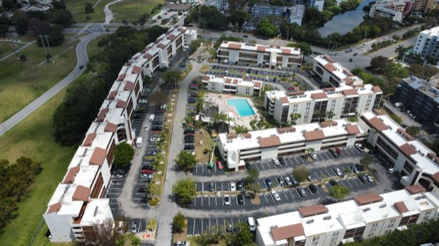 Curved site plan from above, completed roofs across every building.