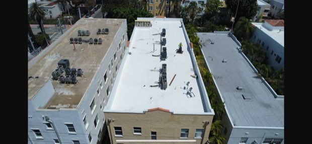 Completed roof on a low-rise building, tile accent band at the eave.
