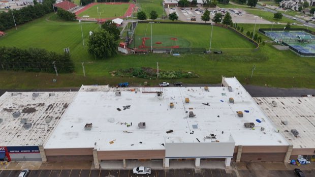 Institutional building roof adjacent to open playing fields.