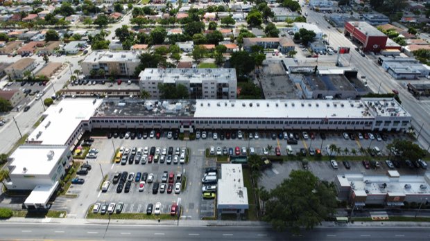 Retail centre from above — roofs, parking field and access lanes.