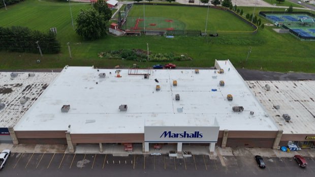 Big-box retail roof, reflective membrane across the full span.