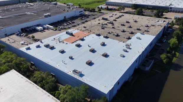Large industrial roof with dense rooftop mechanical equipment.