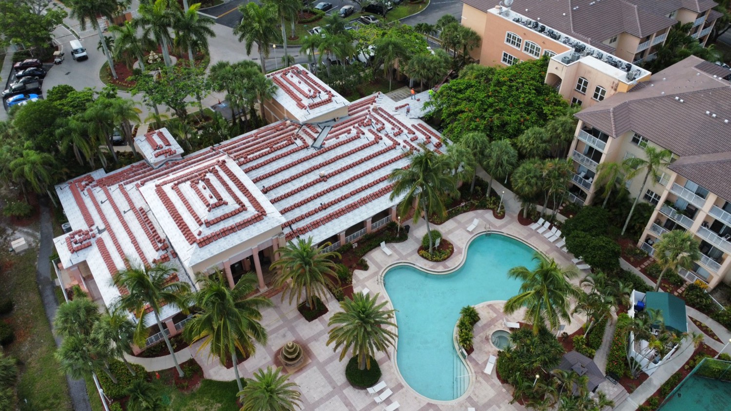 Barrel tile and low-slope roofs around a pool deck on a South Florida property