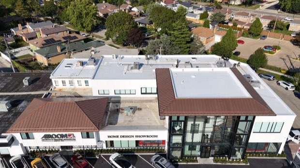 Mixed-use building with completed roofing above ground-floor retail.